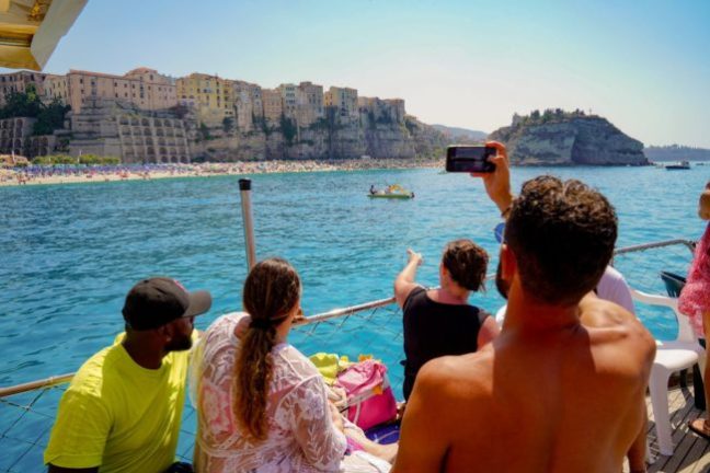 a group of people standing in front of a body of water